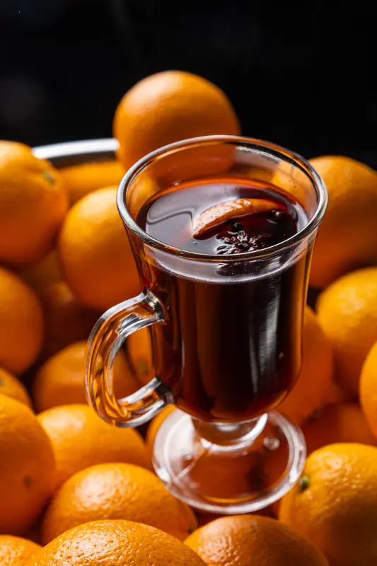 Grzane wino w szklance na tle pomarańczy
